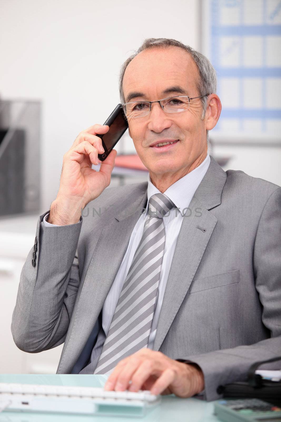senior businessman on the phone by phovoir