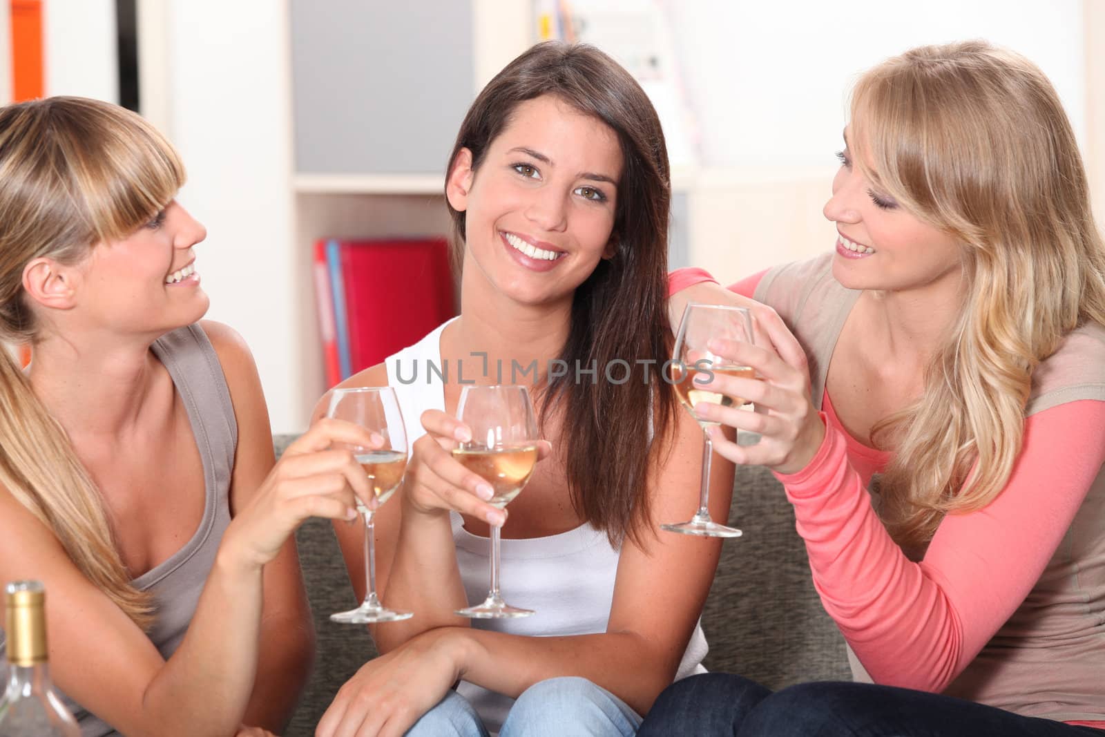 three girlfriends drinking wine together by phovoir