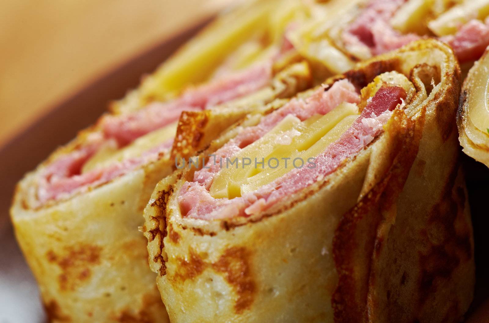 rolled pancakes stuffed ham and cheese. Shallow depth-of-field.