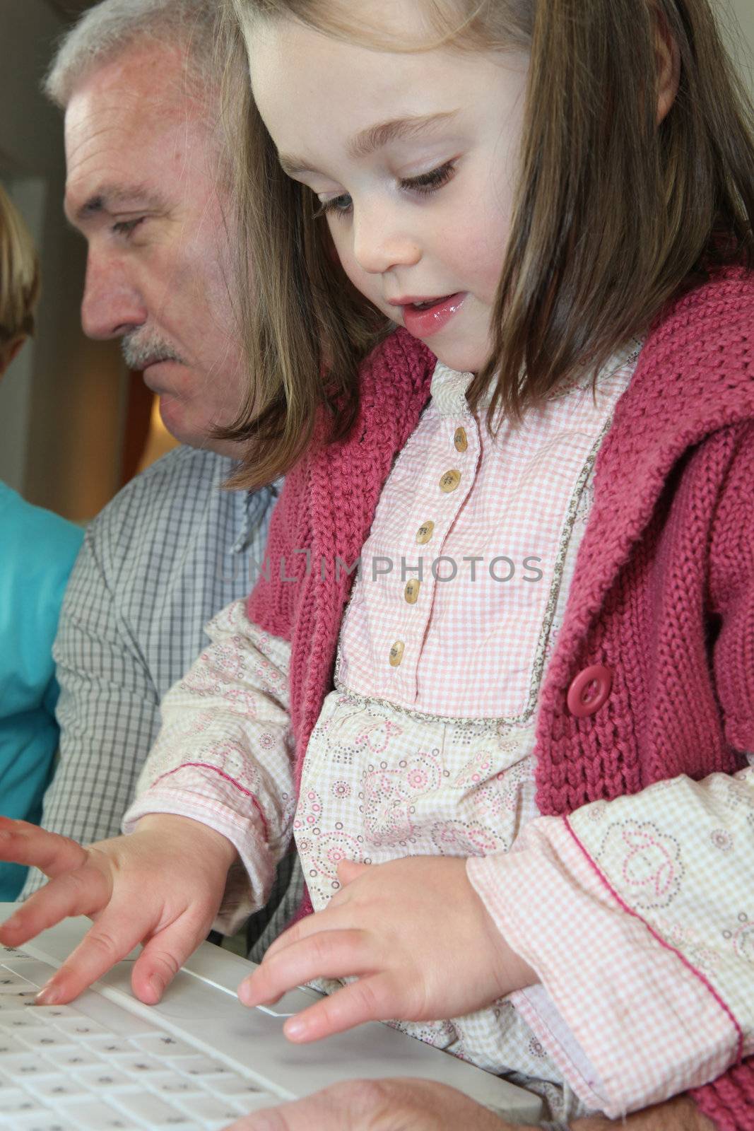 Young girl using a computer keyboard by phovoir
