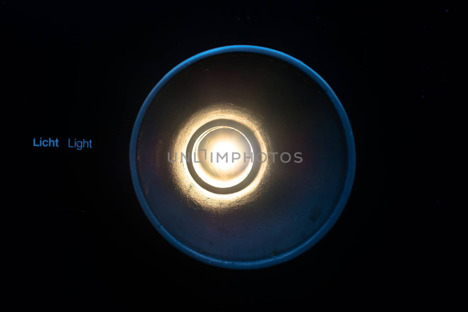abstract light concept: Light shining through a tube with text light (in English and German) next to it