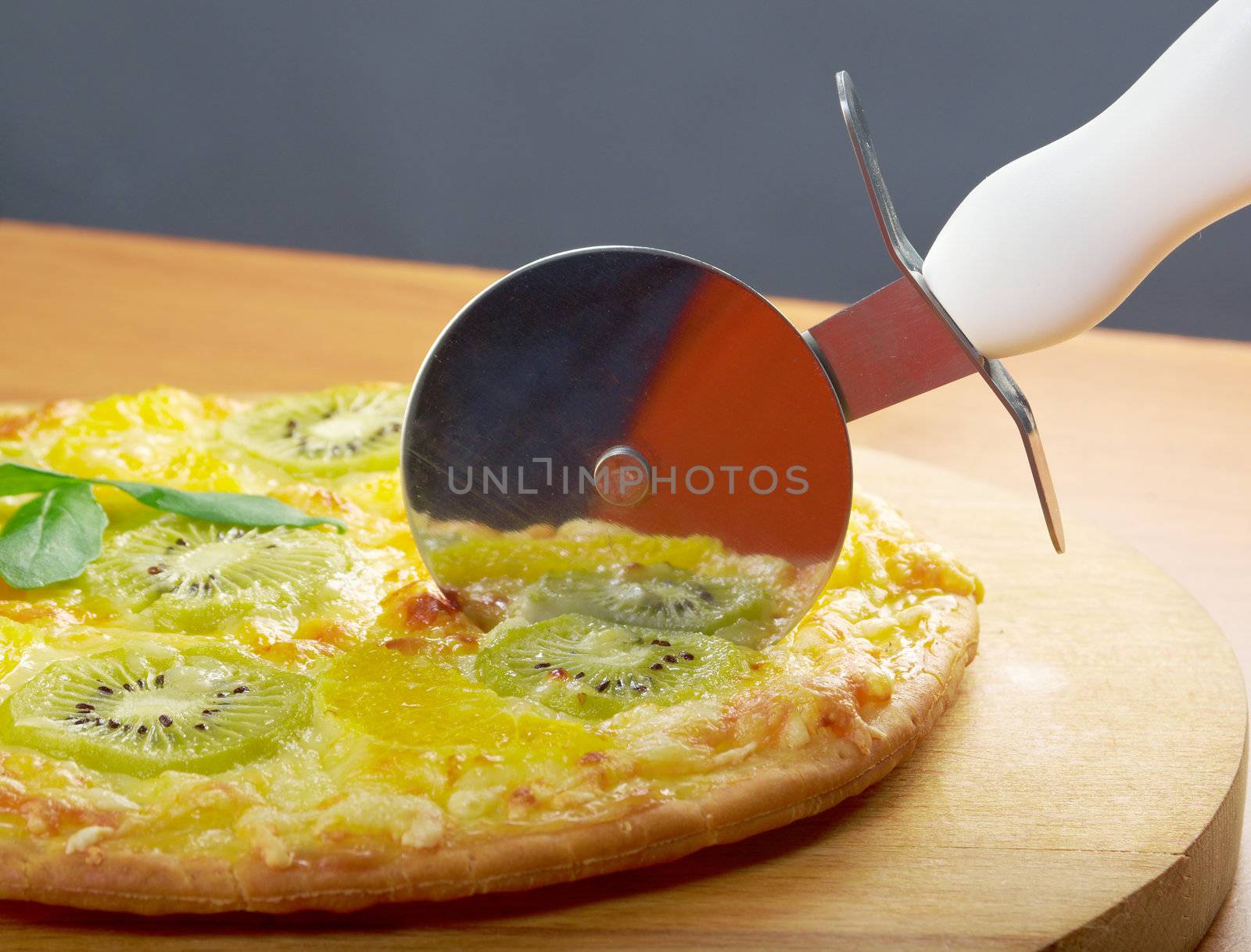 homemade sweet pizza with fruit.Closeup  a knife cut the pizza 