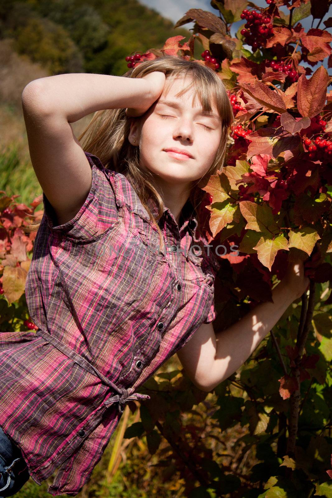 girl near the ashberry bush shrub with closed eyes