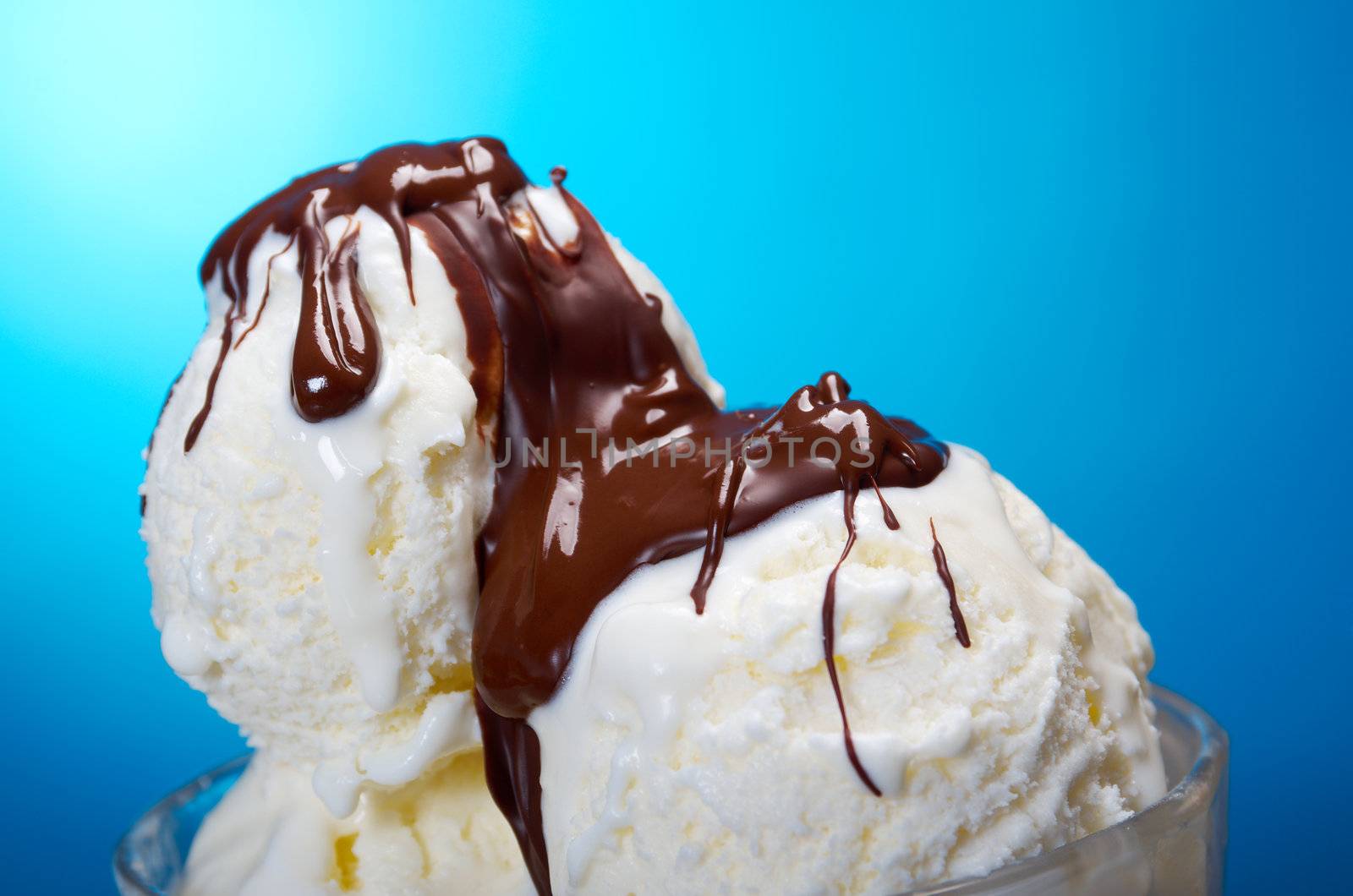 ice cream in with chocolate sauce. closeup .on blue background.
