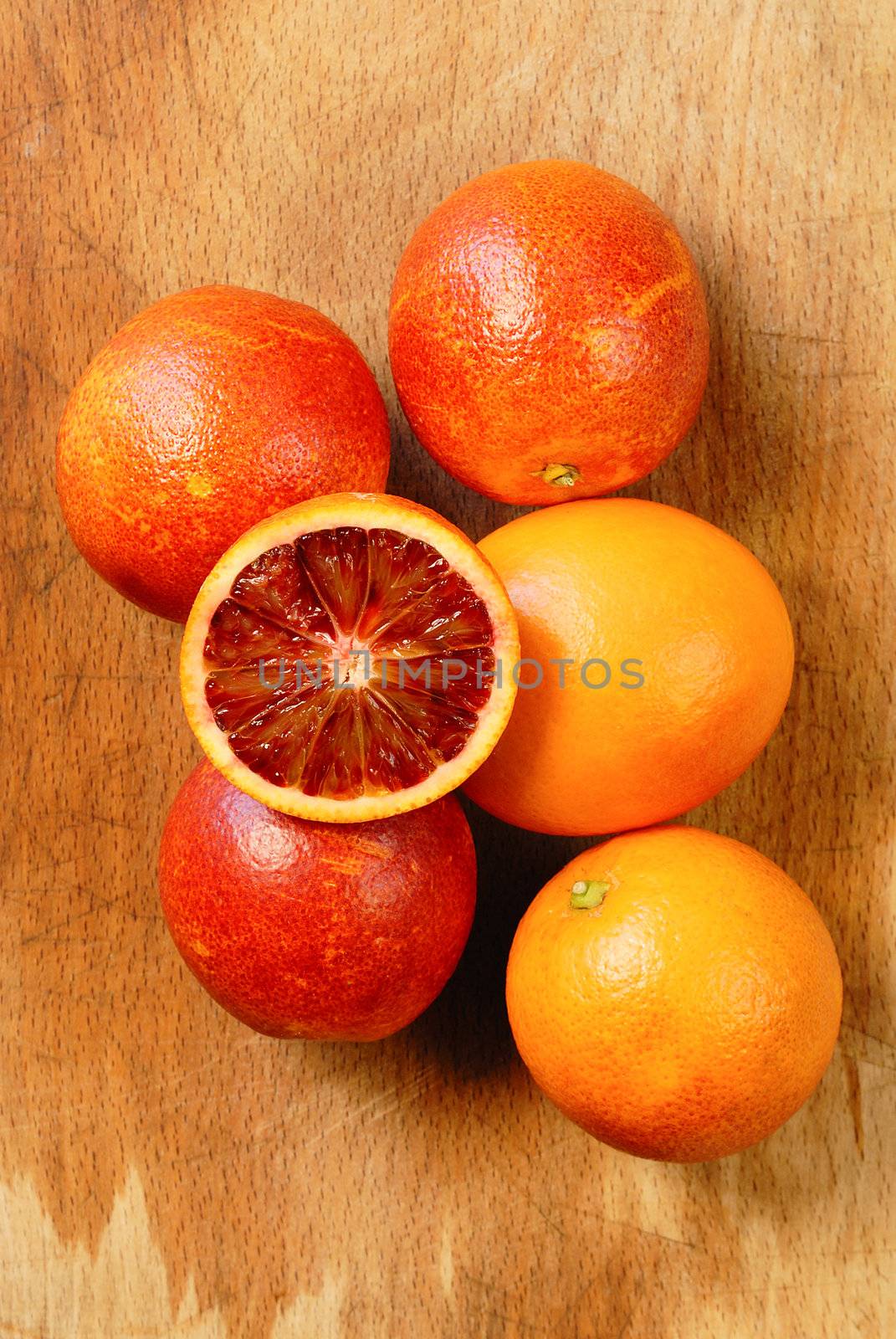 Blood red oranges isolated on wooden background 