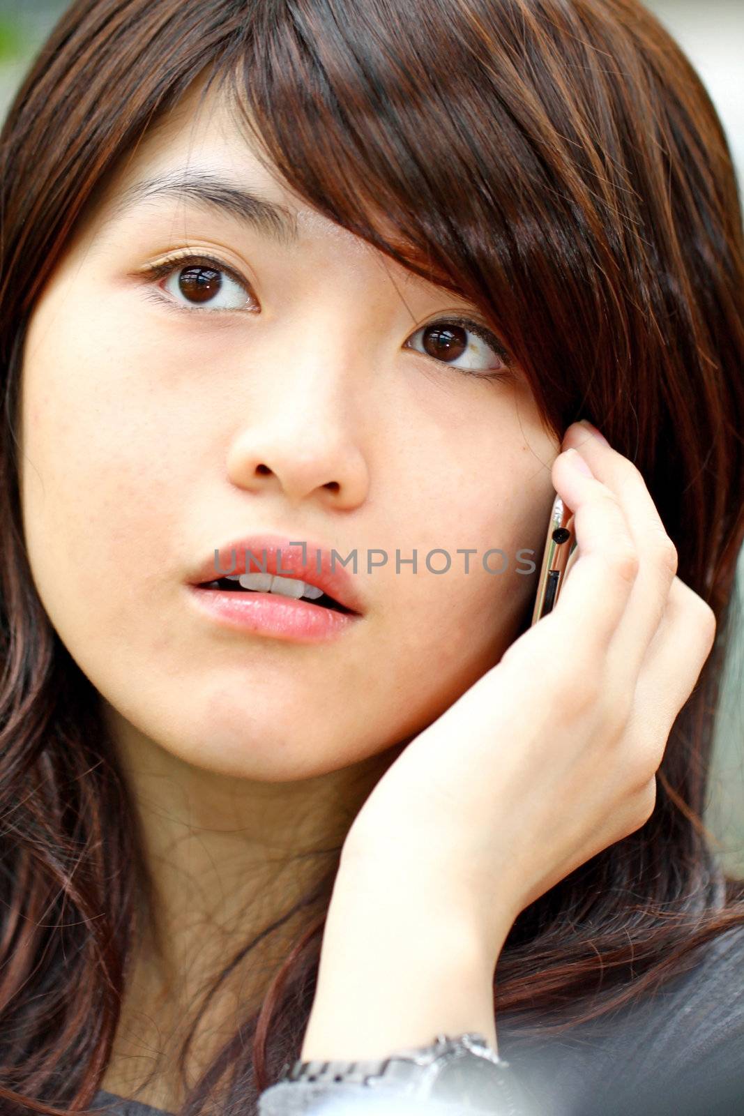 Asian woman talking on phone with curious face