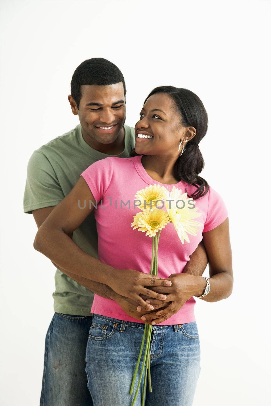 Portrait of smiling African American couple standing looking at each other.