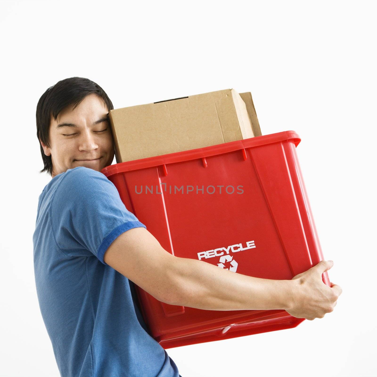 Portrait of smiling Asian young man holding recycling bin.