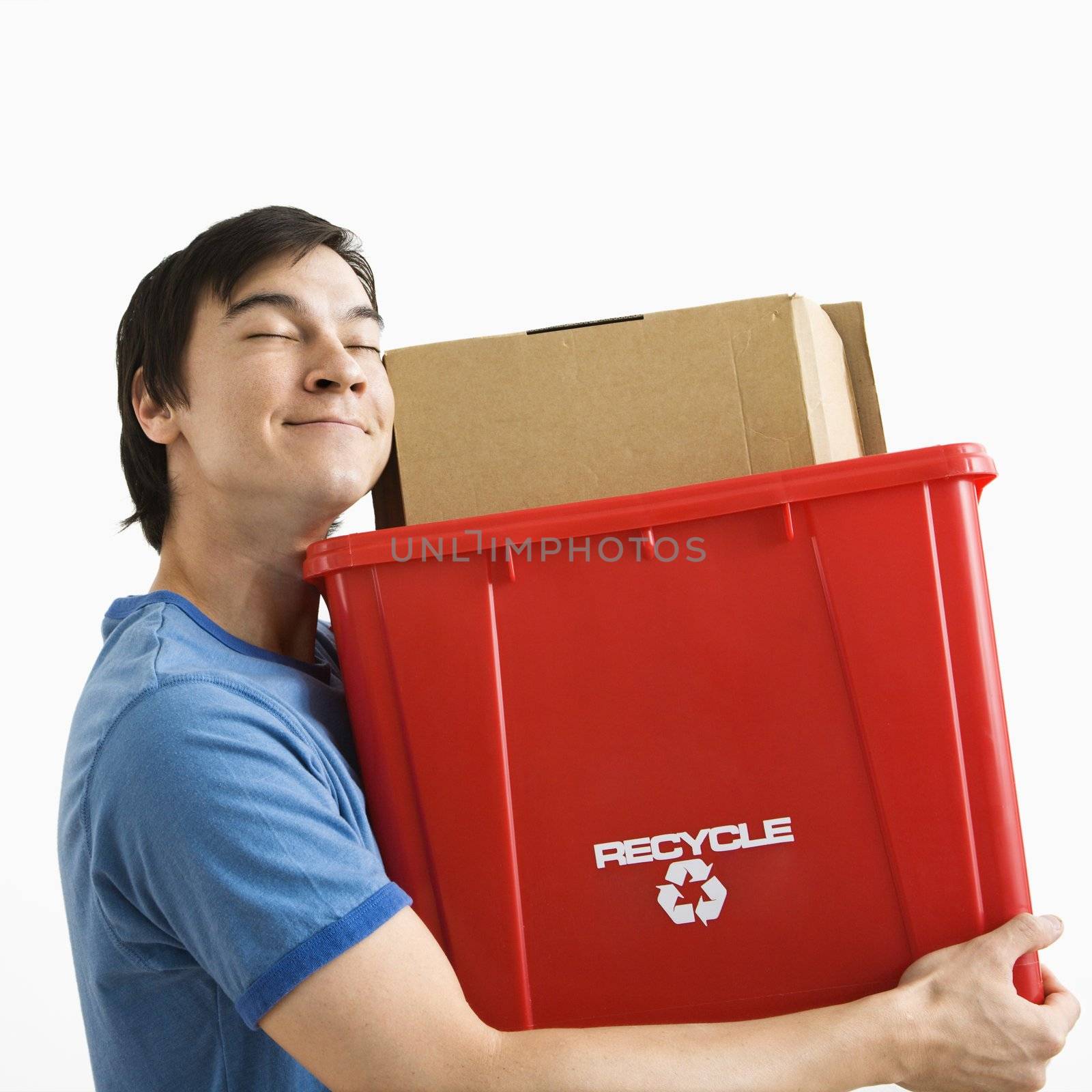 Portrait of smiling Asian young man holding recycling bin.