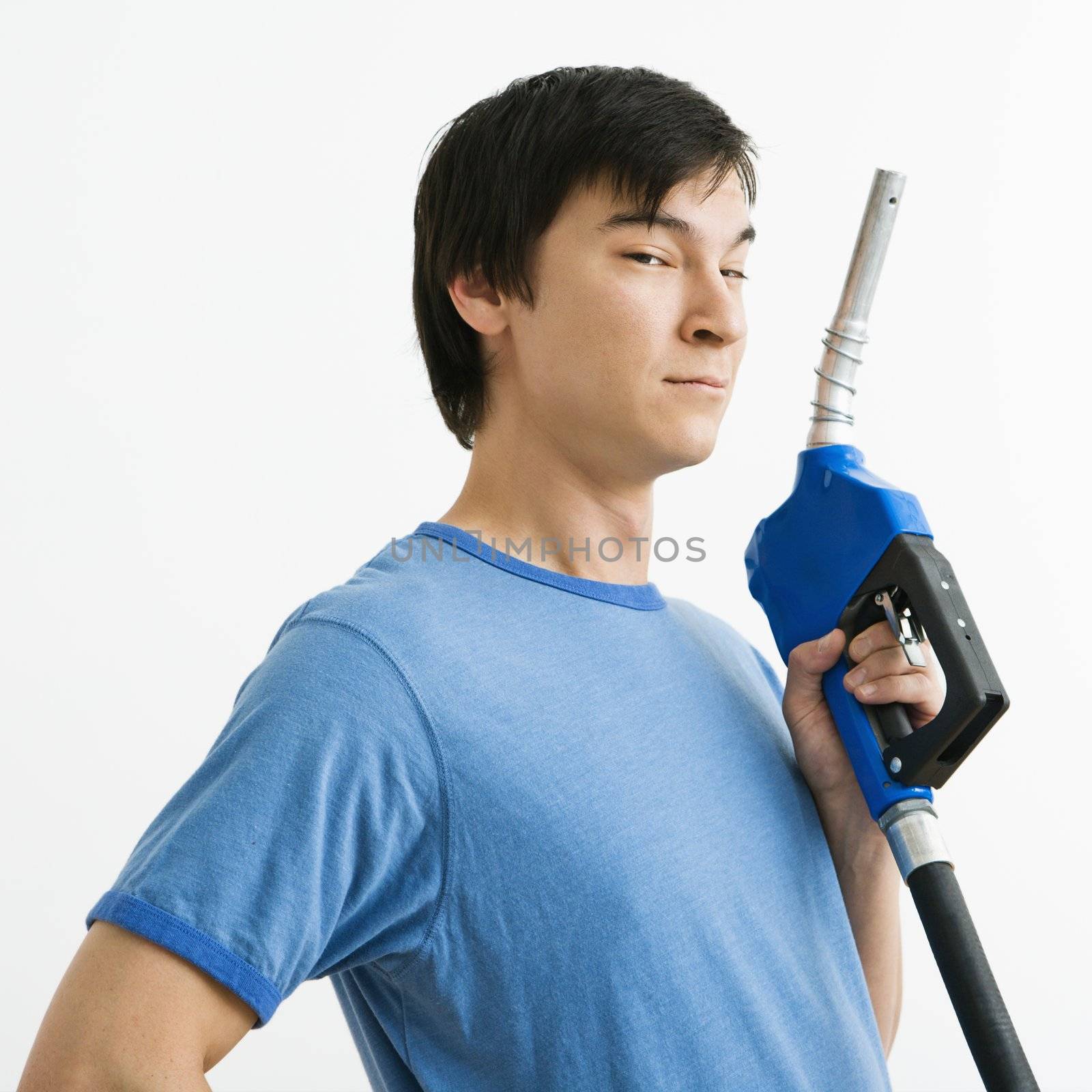 Asian young man holding gasoline pump nozzle.