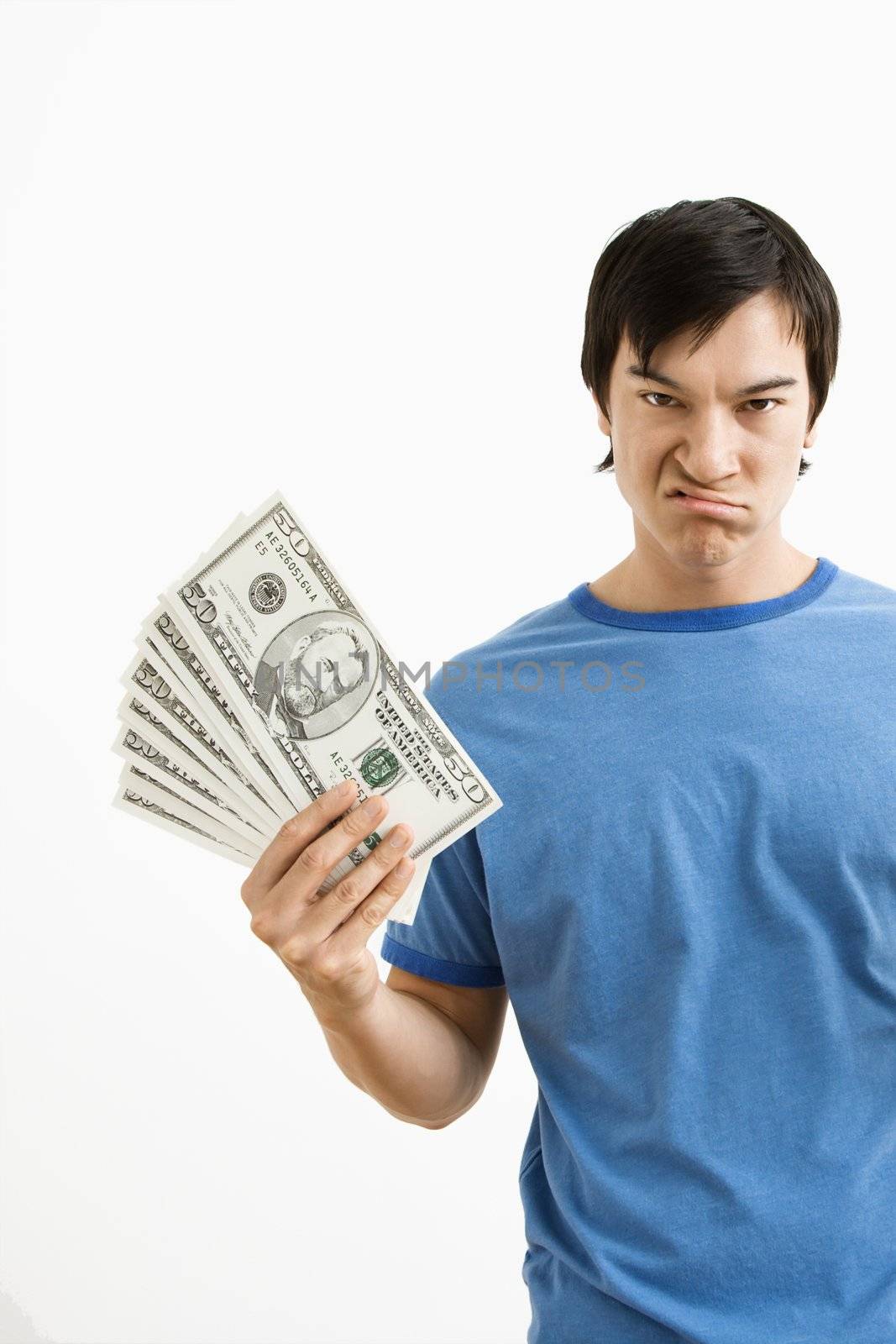 Asian young man holding money with disgust on his face.