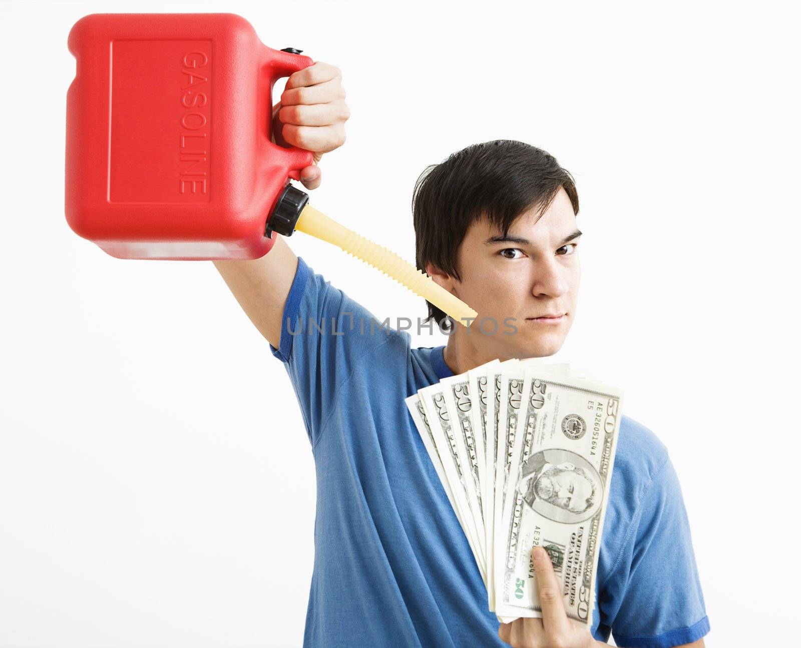 Asian young man holding gas can pouring gasoline onto money.