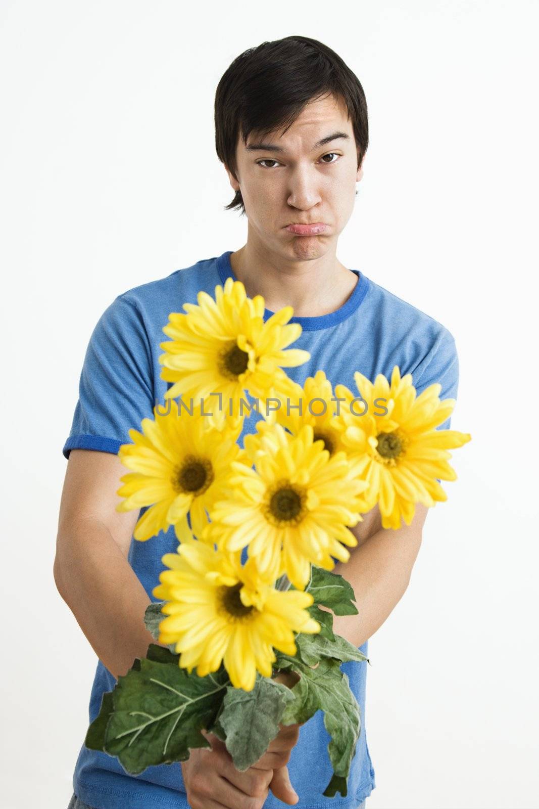 Pouting man holding bouquet. by iofoto