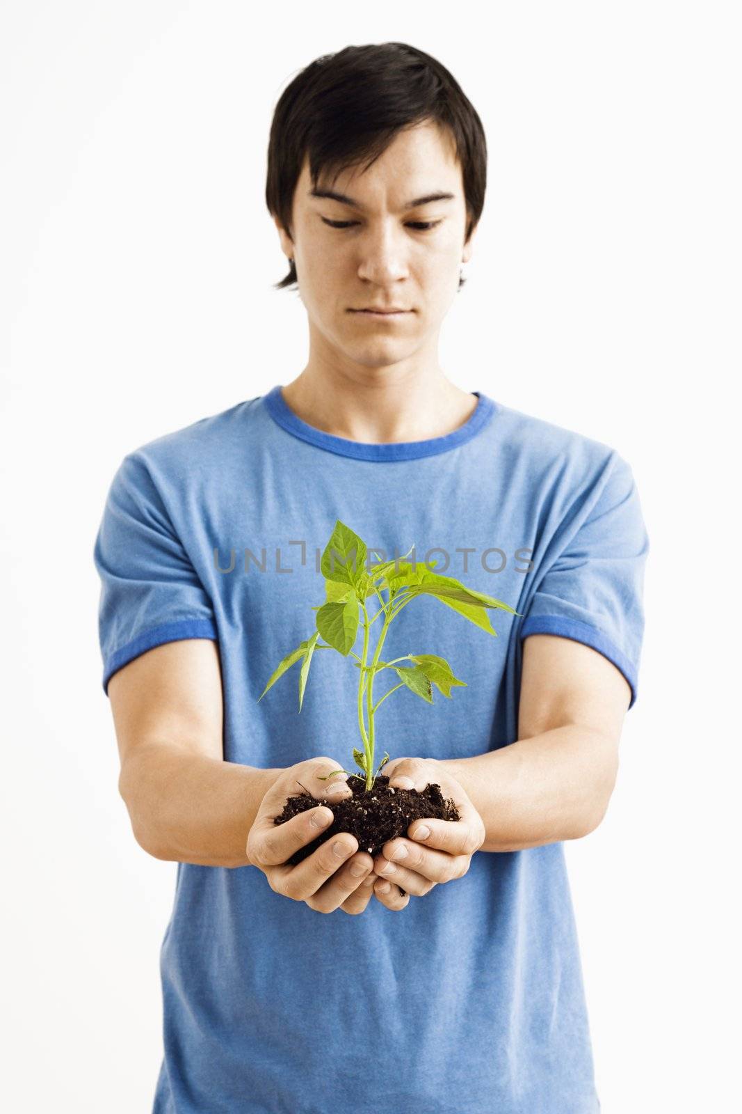 Man holding plant. by iofoto