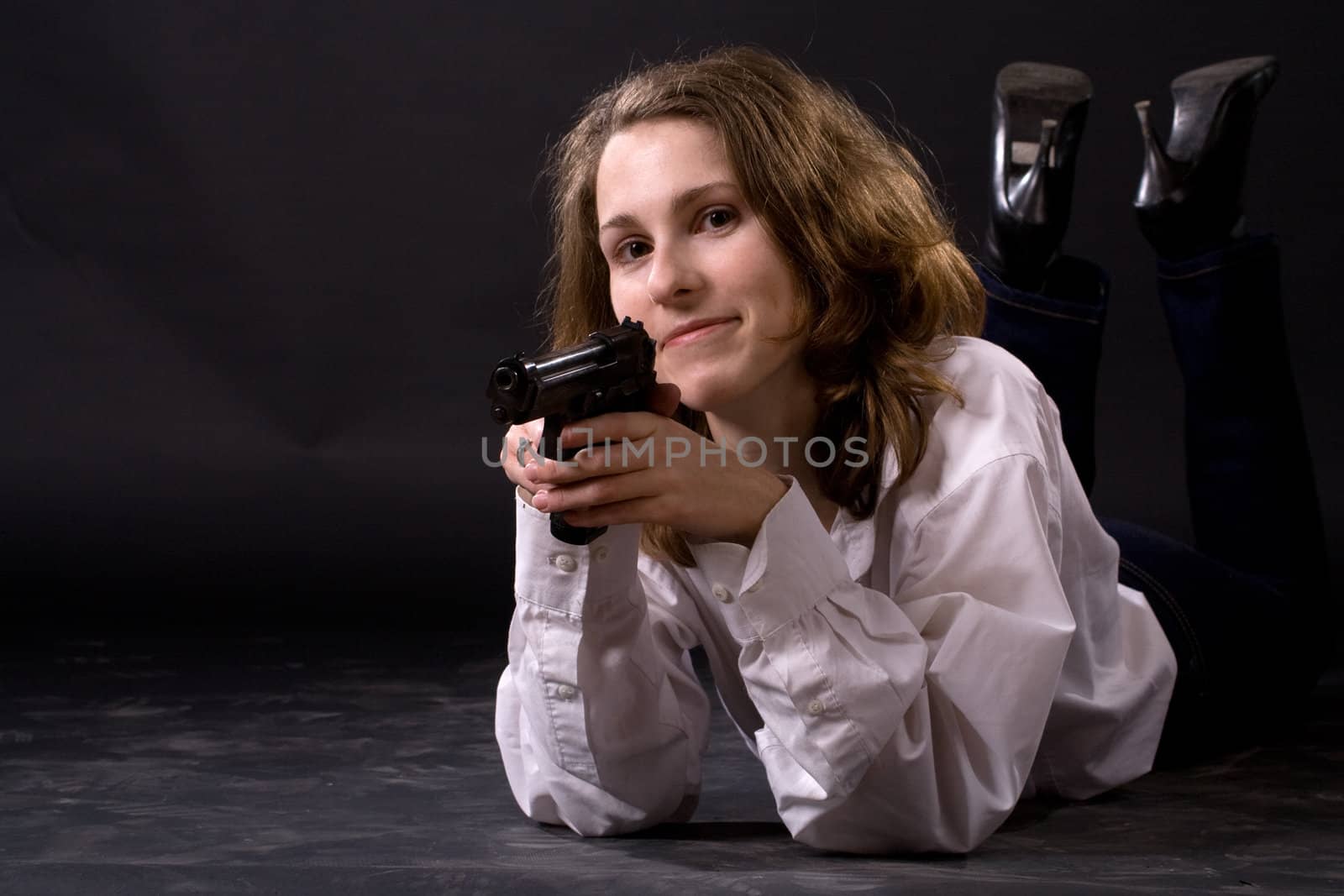 lying woman on black with gun
