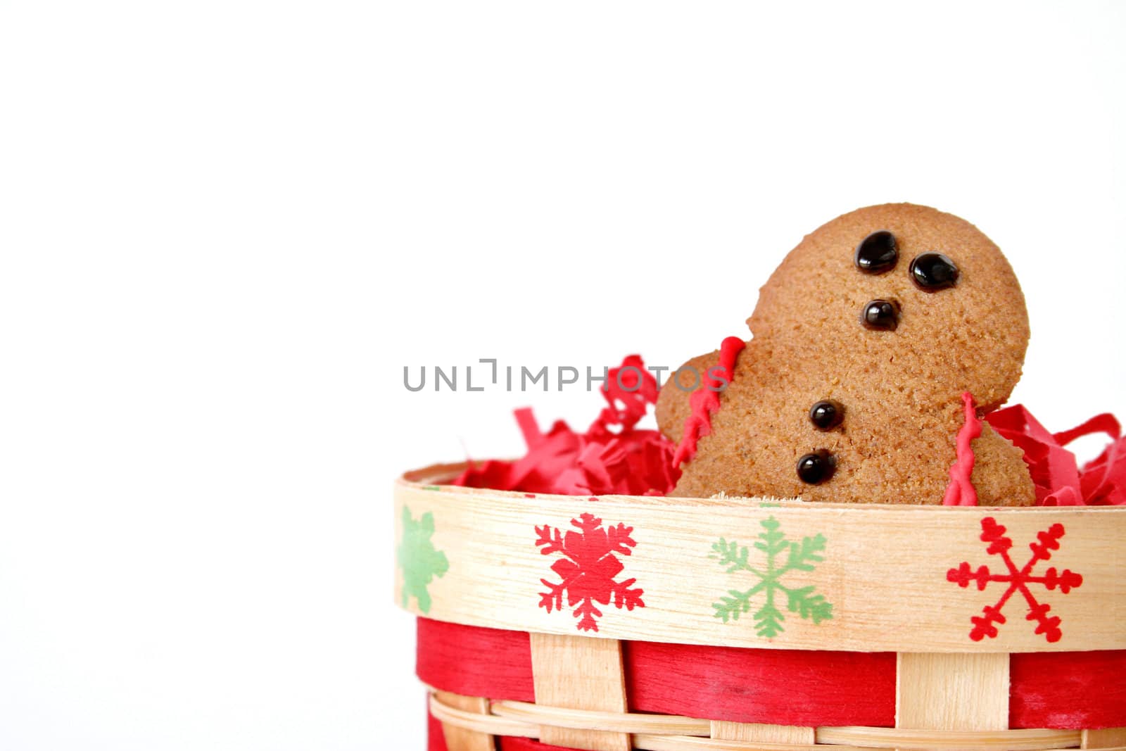 Isolated gingerbread man in a Christmas themed basket.