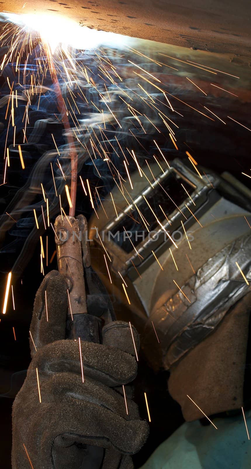 a welder working at shipyard under vessel