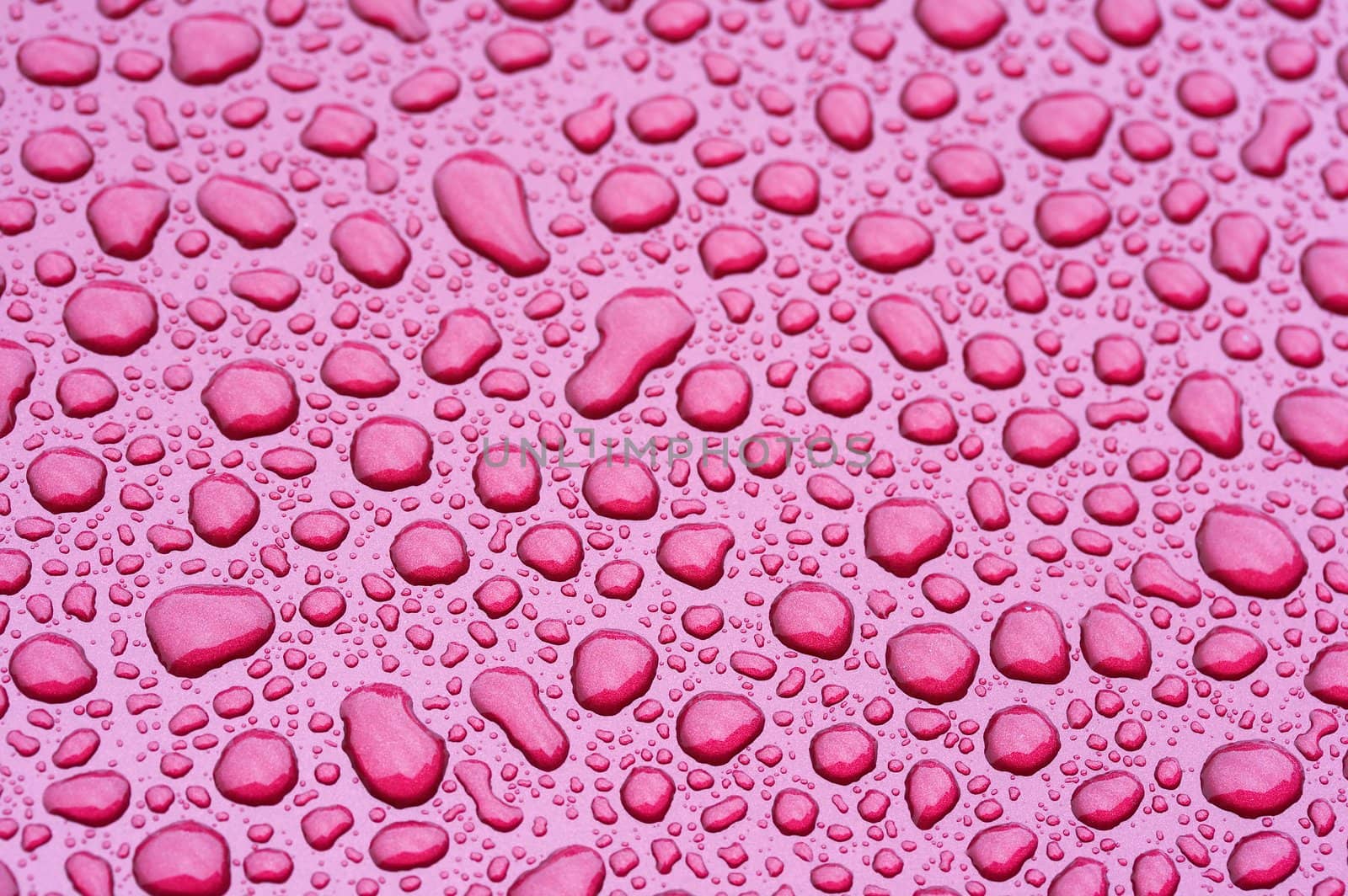 a picture of water drops on a red metal surface