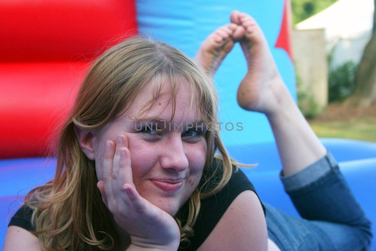 Victoria smiling, laying down on a bouncy castle.