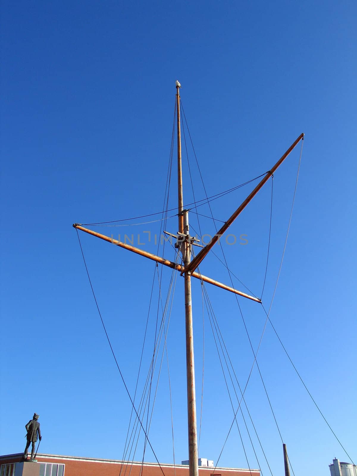 Traditional wooden mast of an old sail boat with clear sky background  