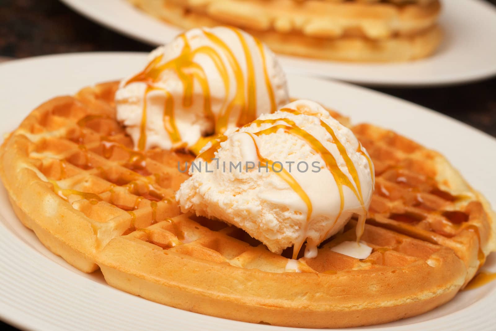 Belgian waffles with ice-cream and syrup on white plate
