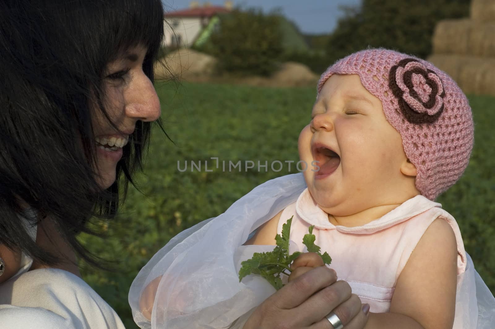baby girl with her mother is laughing a lot.