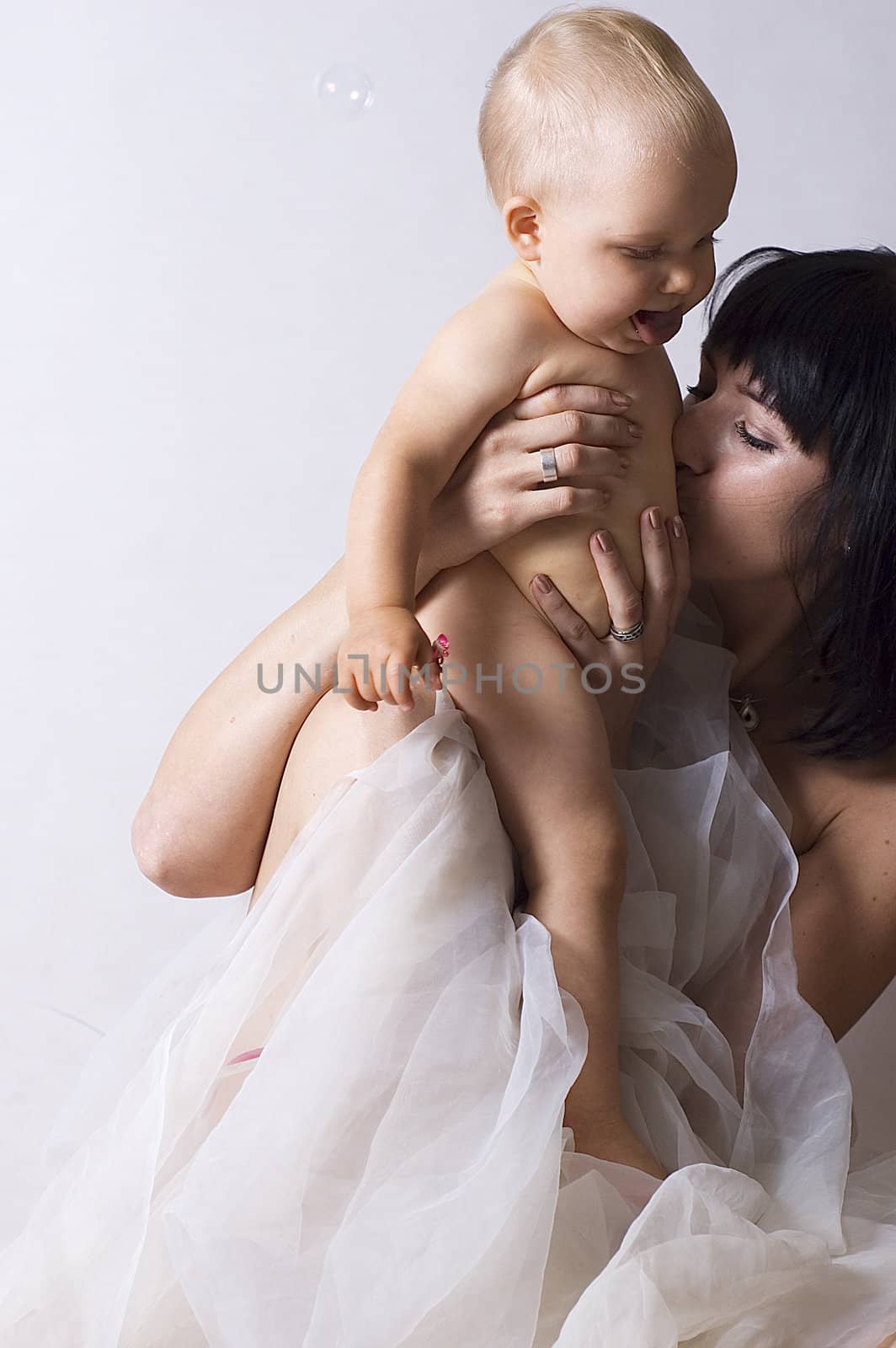 mother kissing little baby on the belly. portrait witch present amazing love