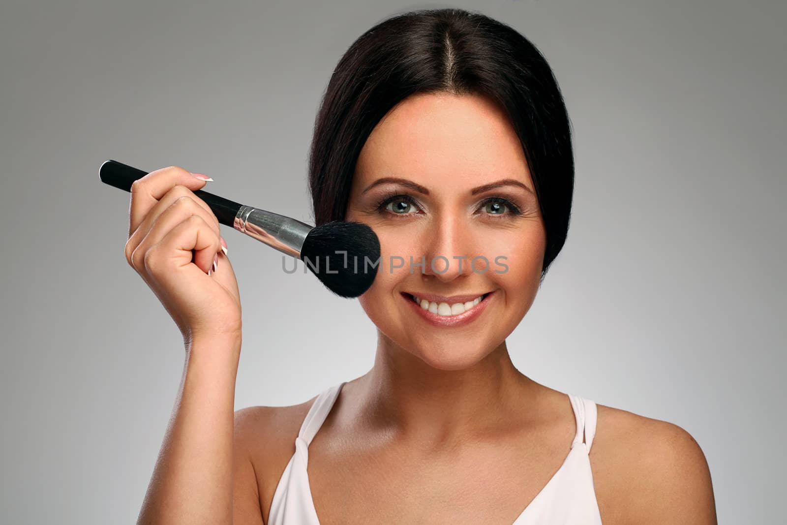 Beautiful woman with natural makeup and brush isolated over background