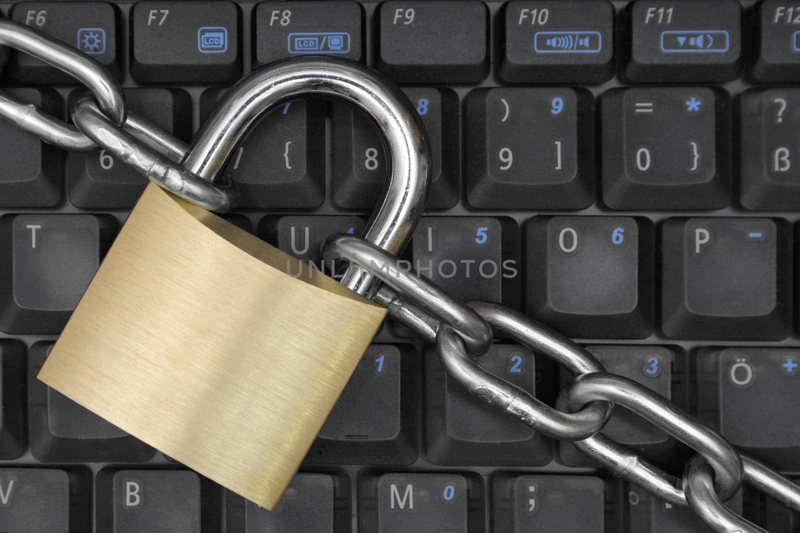 Padlock and chain locking a notebook keyboard.