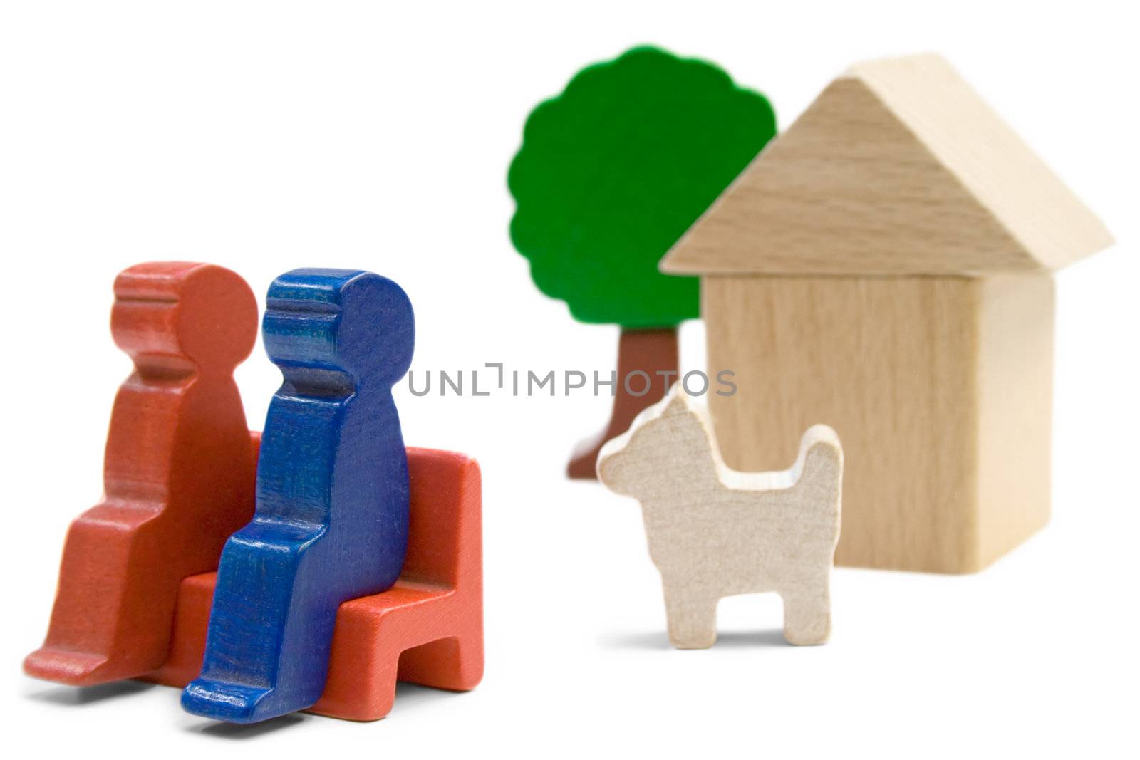 Couple with dog sitting in front of their home. Playthings isolated on a white background.