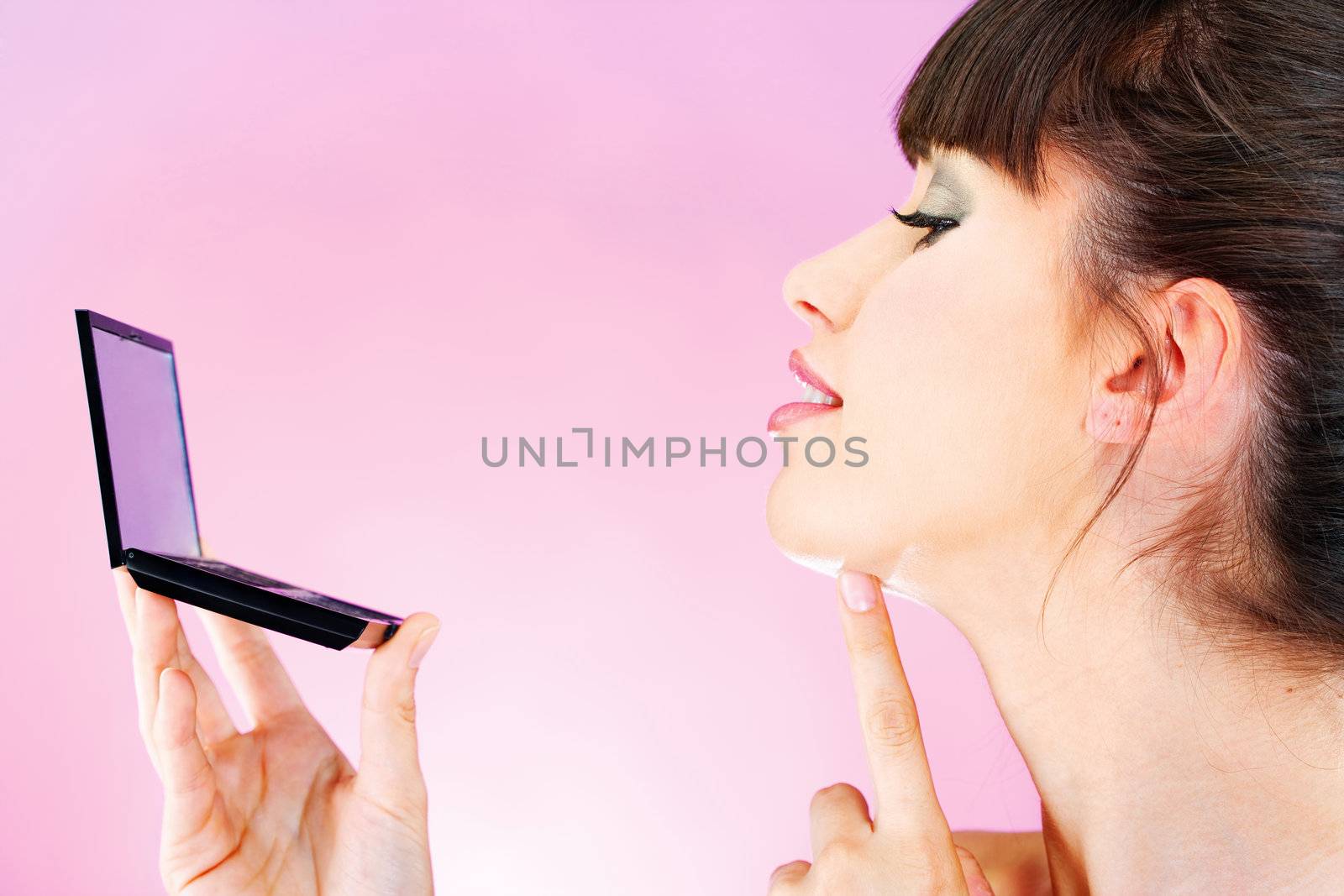 woman checking face skin in mirror by imarin