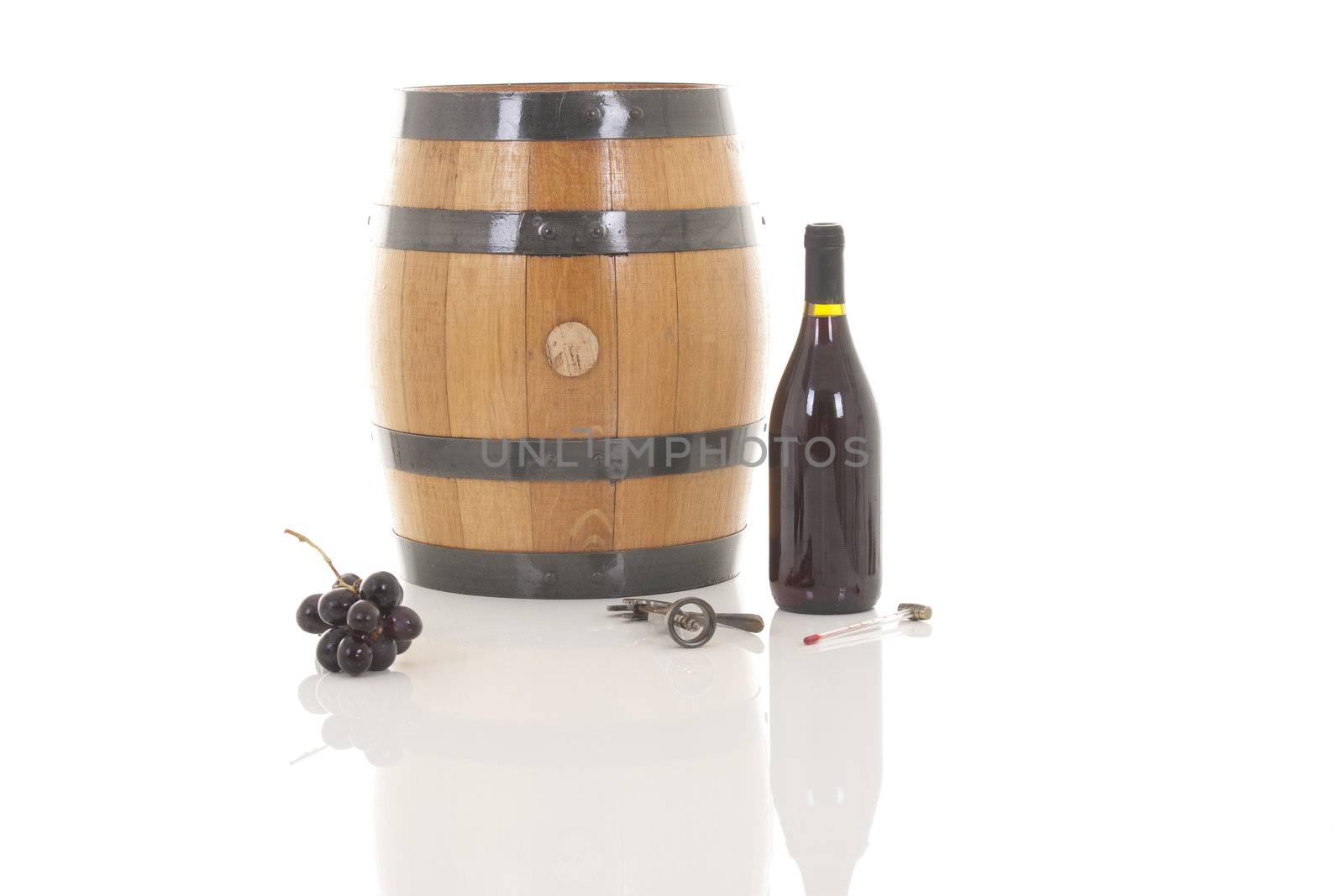 Red wine with grapes and barrel over white background