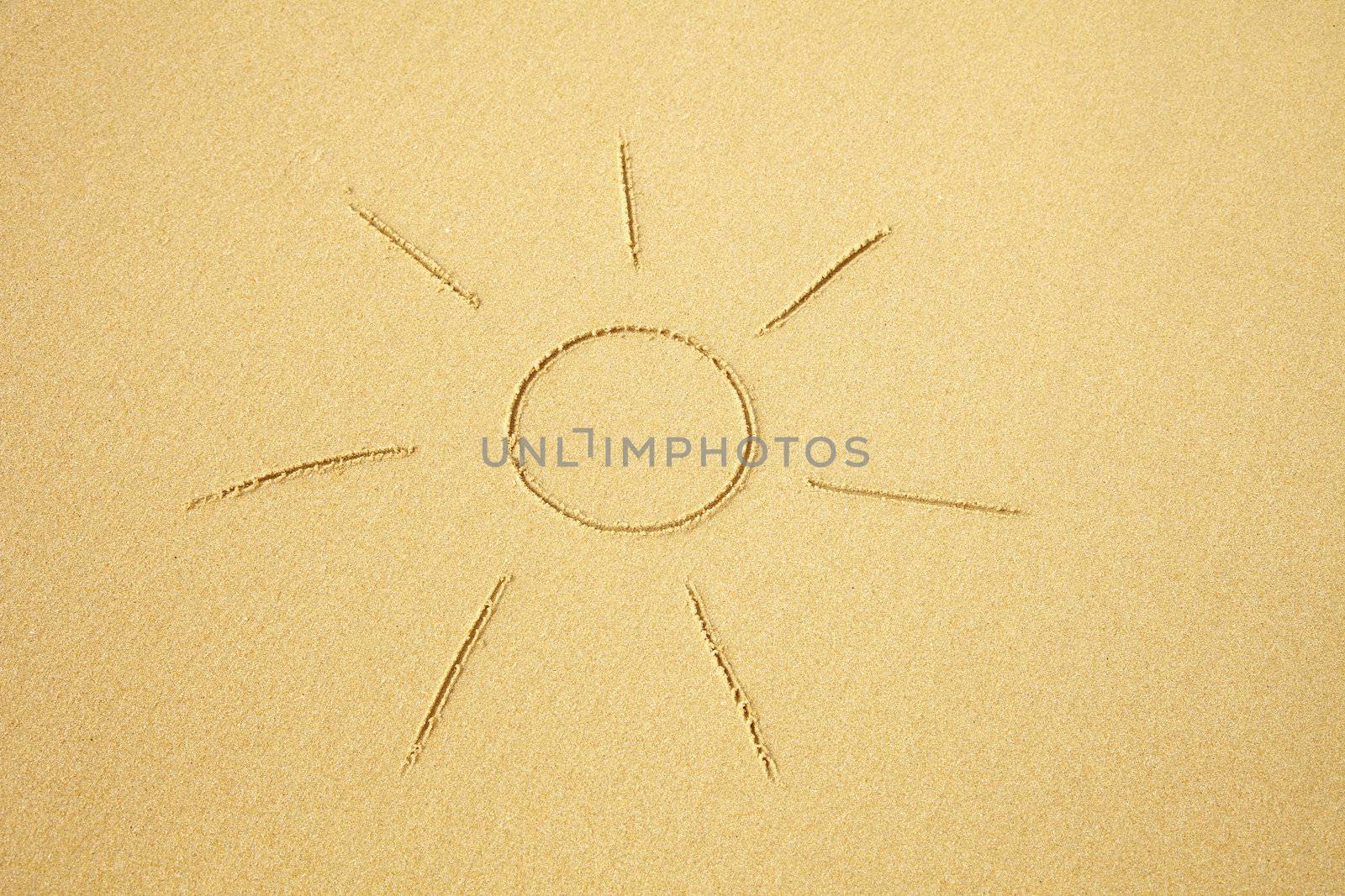 Simple sun drawn on sand of the beach