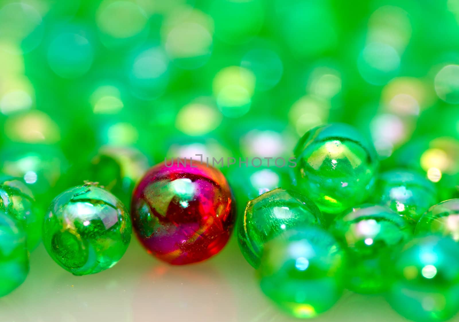 Red beads among the green smaller beads with mirror image in landscape orientation