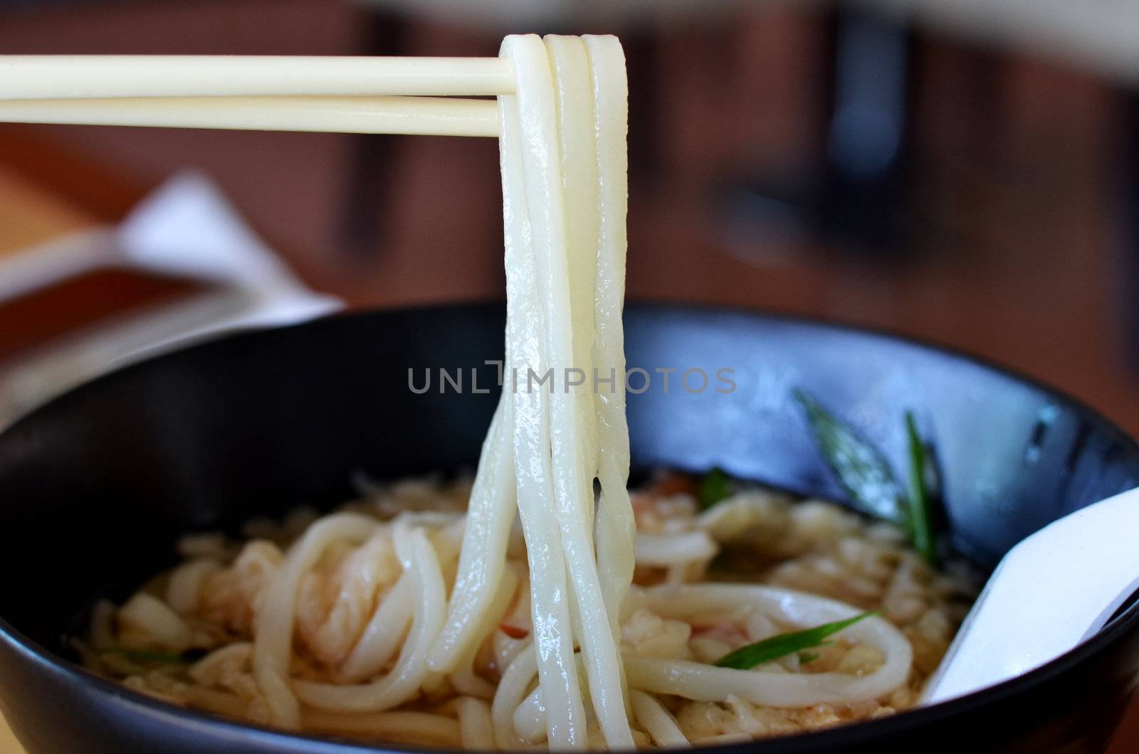 Udon noodle on chopsticks , noodle with shrimp tempura