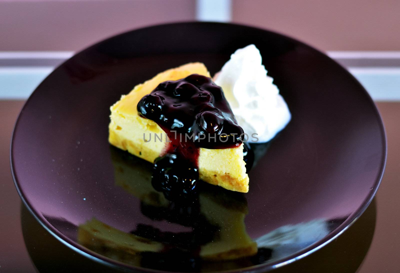 a slice of blueberry cheese cake served with whipped cream