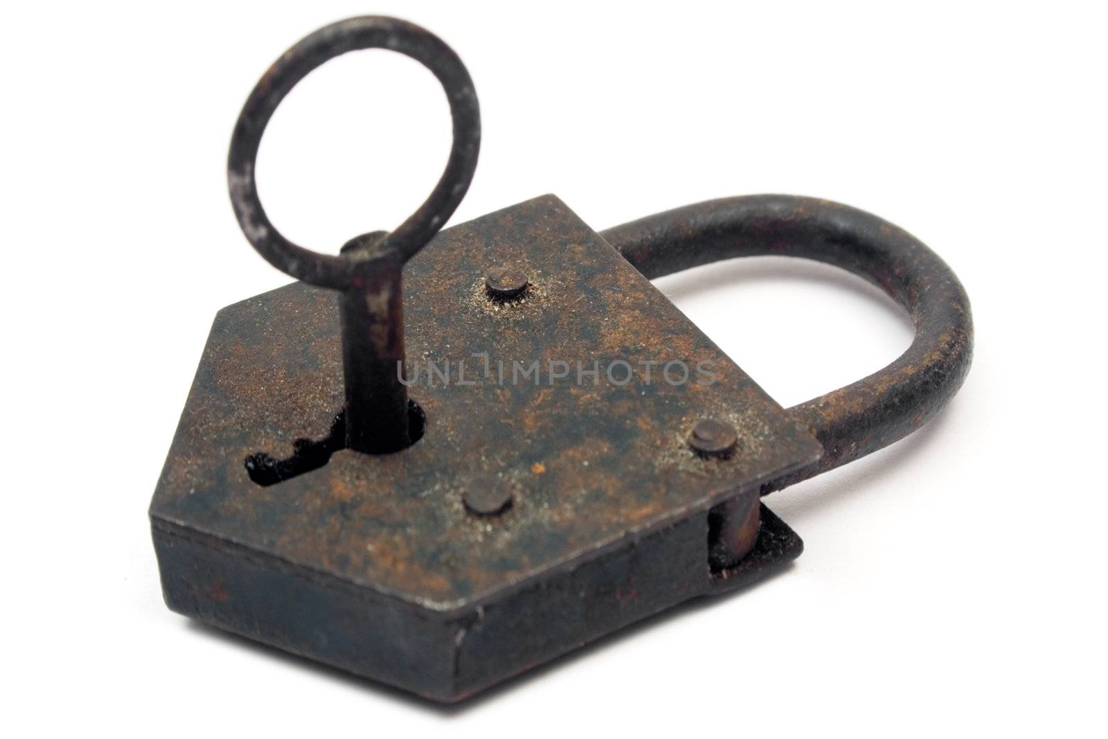 Antique rusty padlock with key. Isolated on white.