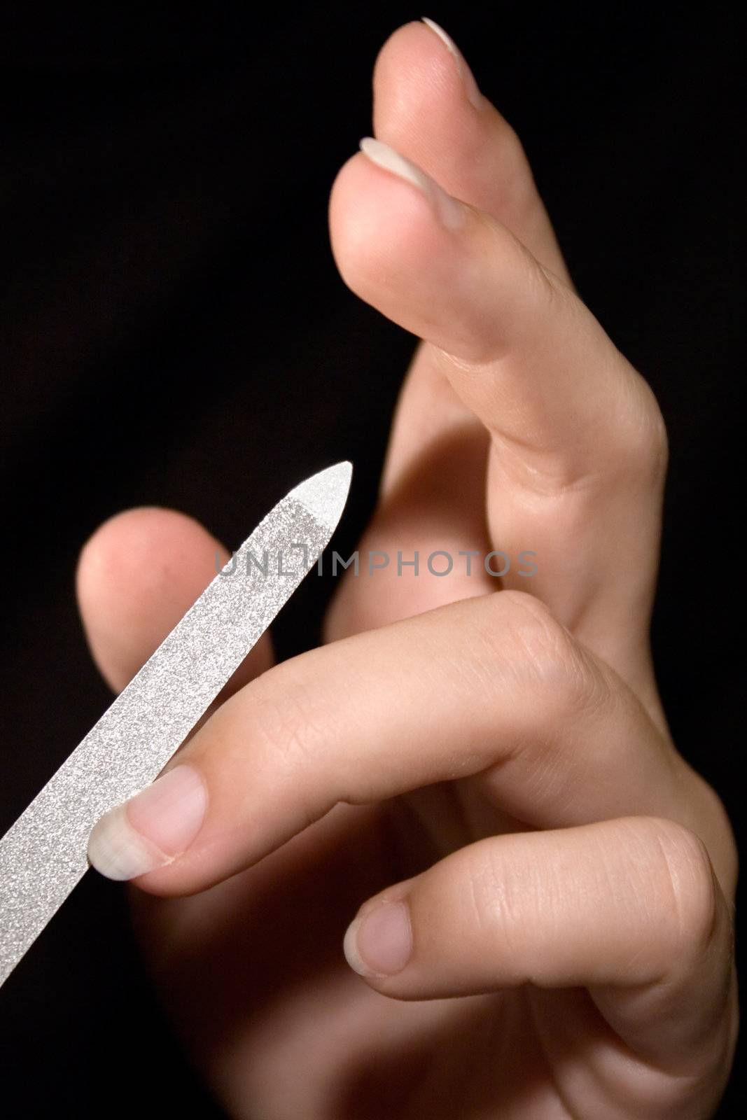 Woman filing her fingernails.