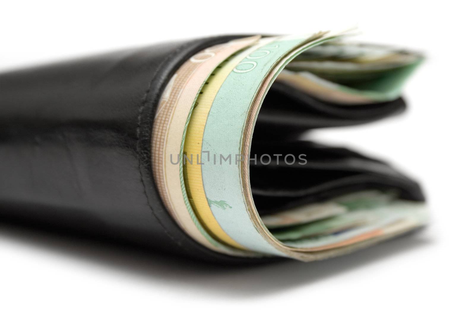 Close view on a black leather wallet full of banknotes. White background.