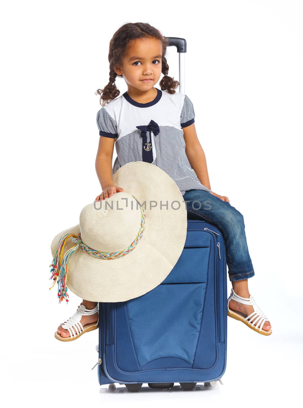 The young mulatto traveler girl with hat and a suitcase. Isolated over white background. Vertical view