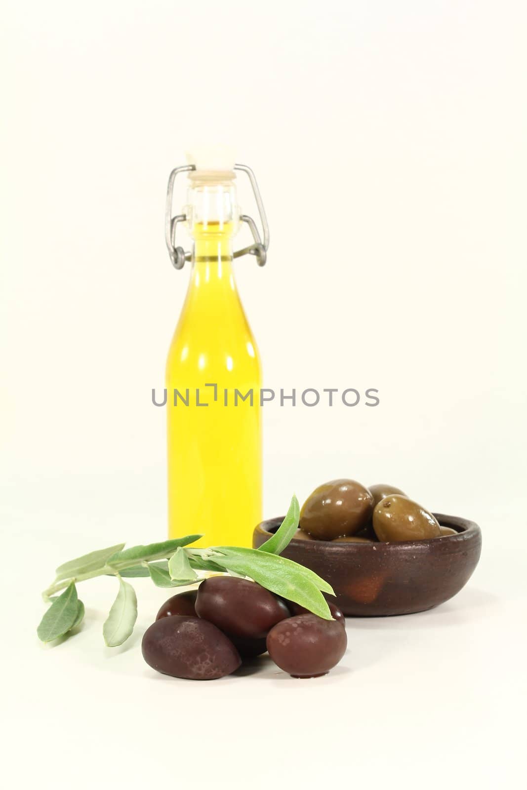 fresh Olive oil with black olives and a olive branch