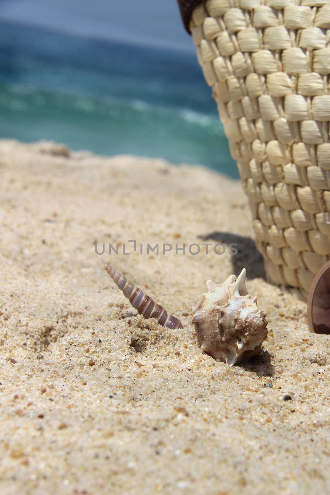 Straw bag on the beach and shells 