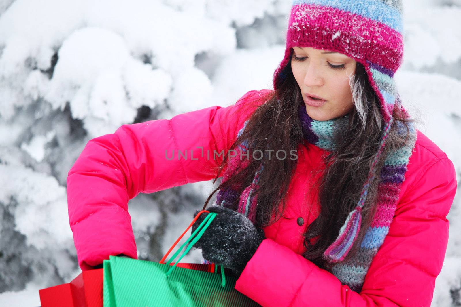 winter girl with gift bags on snow background