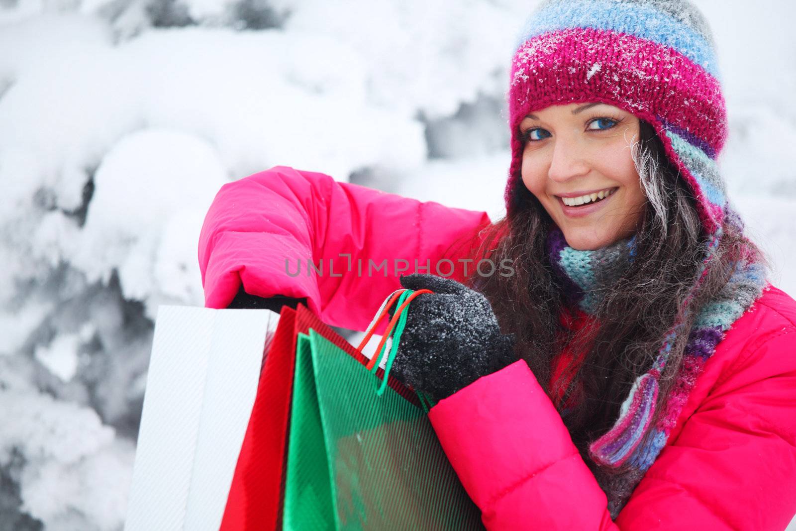 winter girl with gift bags on snow background