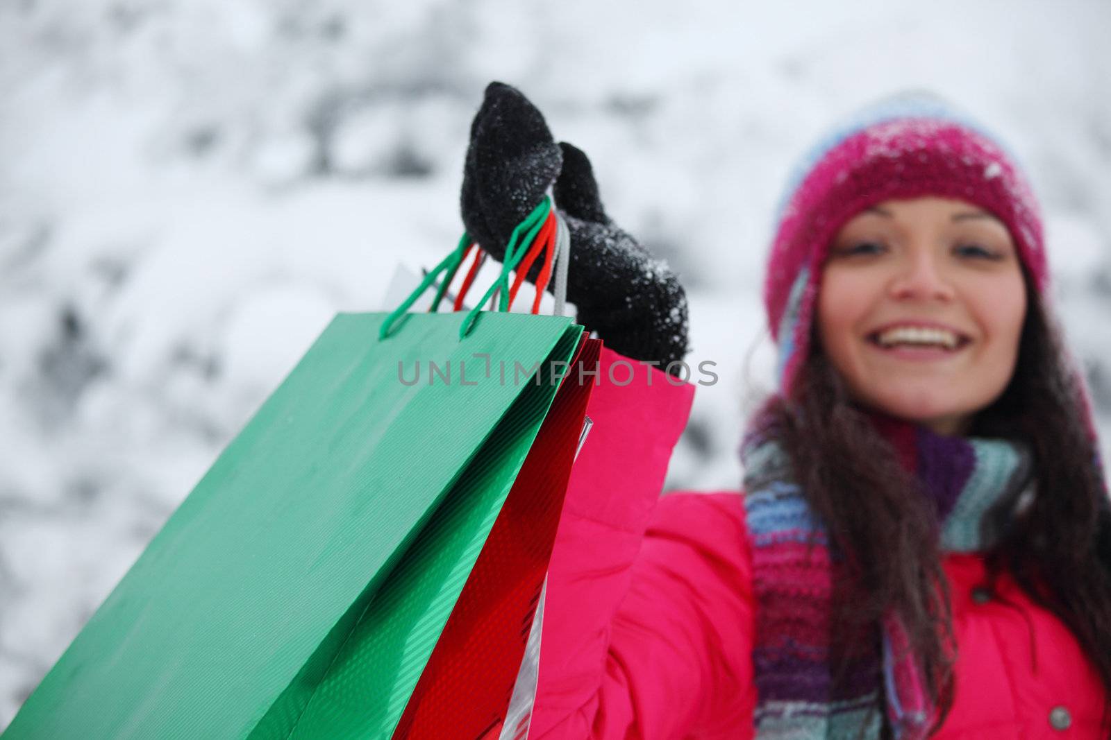 winter girl with gift bags on snow background