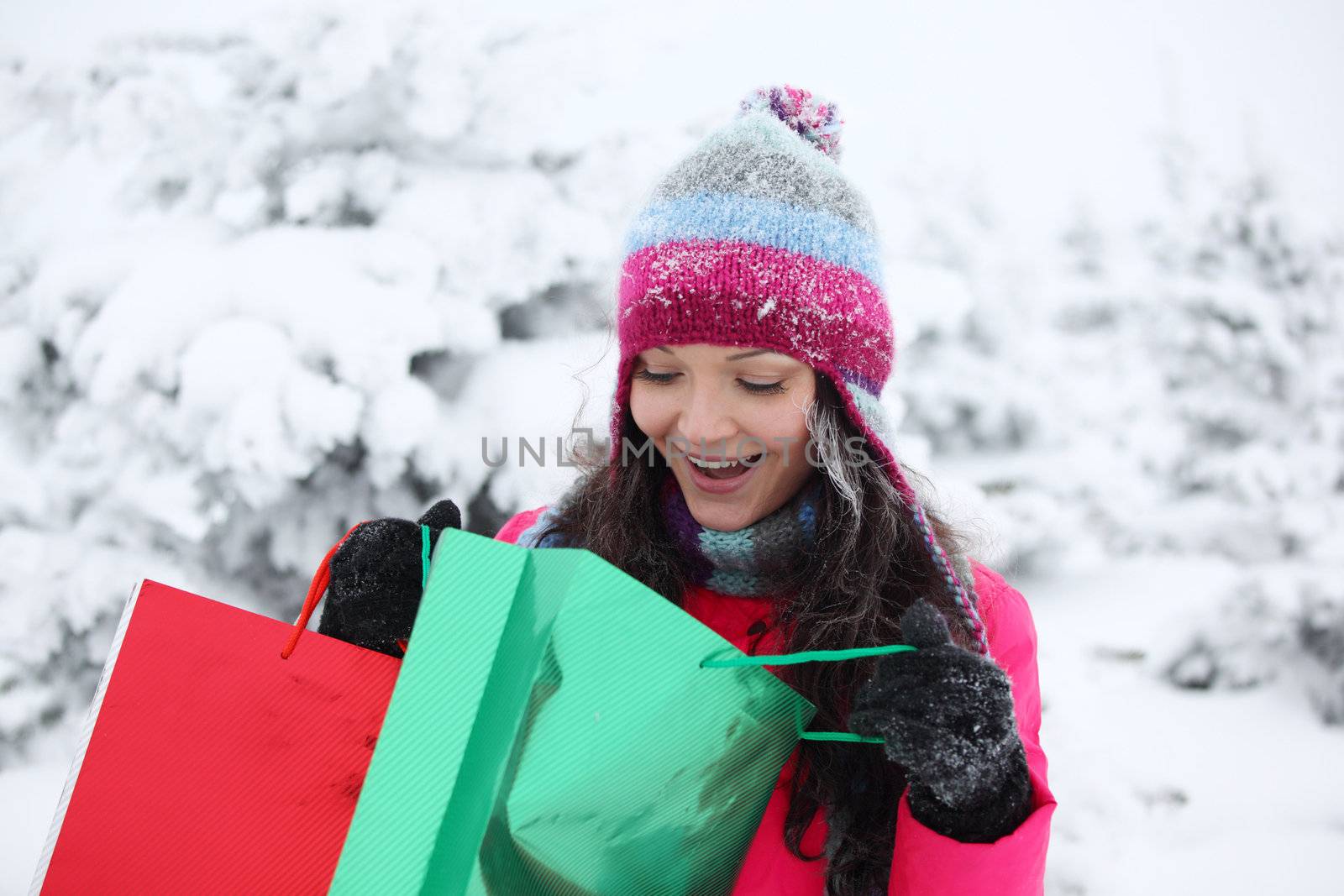 winter girl with gift bags on snow background