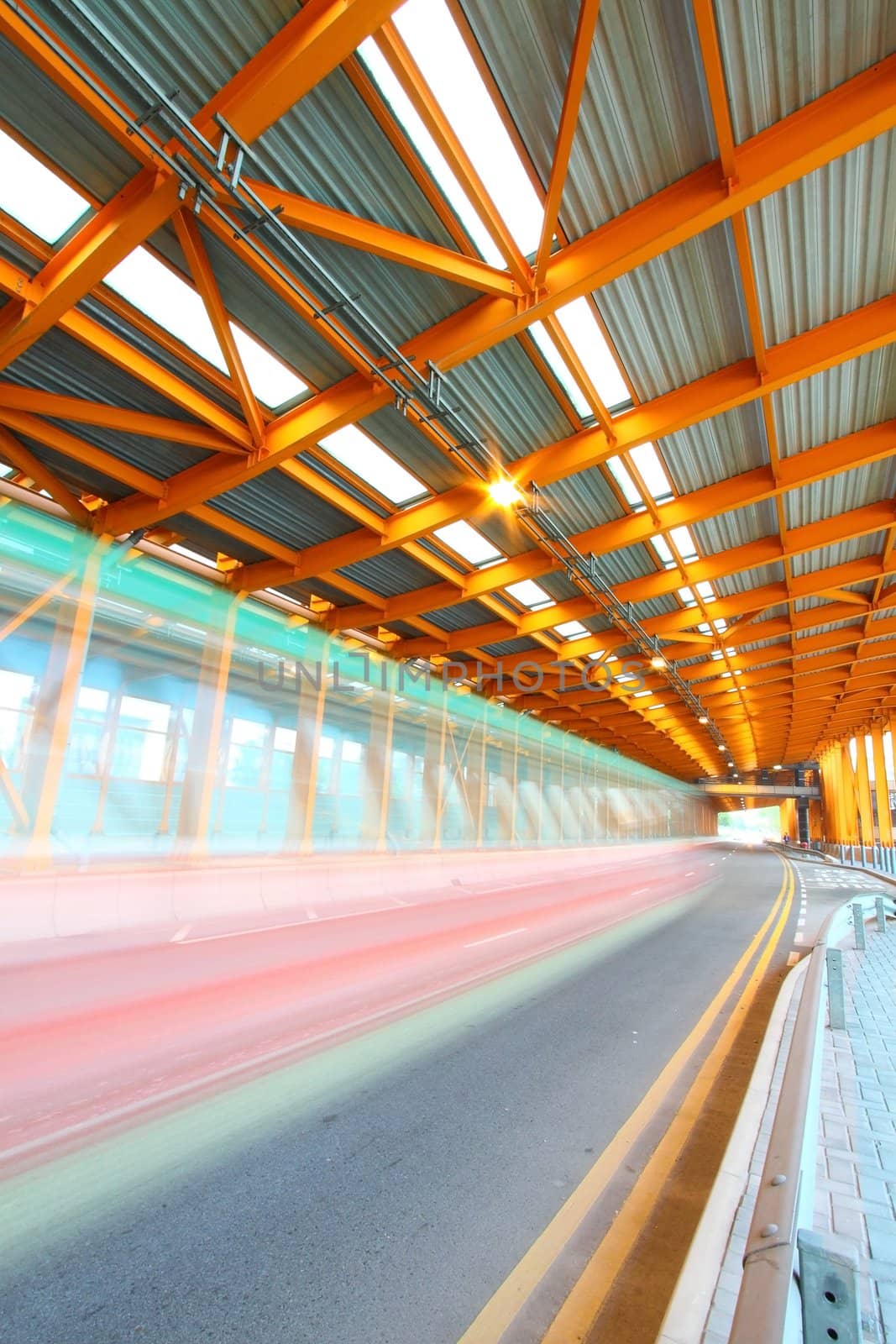 Orange tunnel at daytime with moving bus