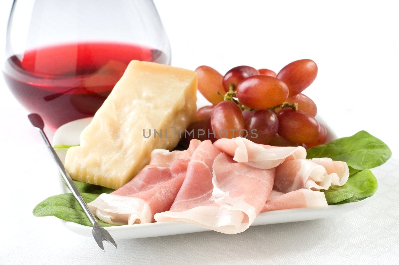 Italian appetizer plate of cheese, grapes and ham.