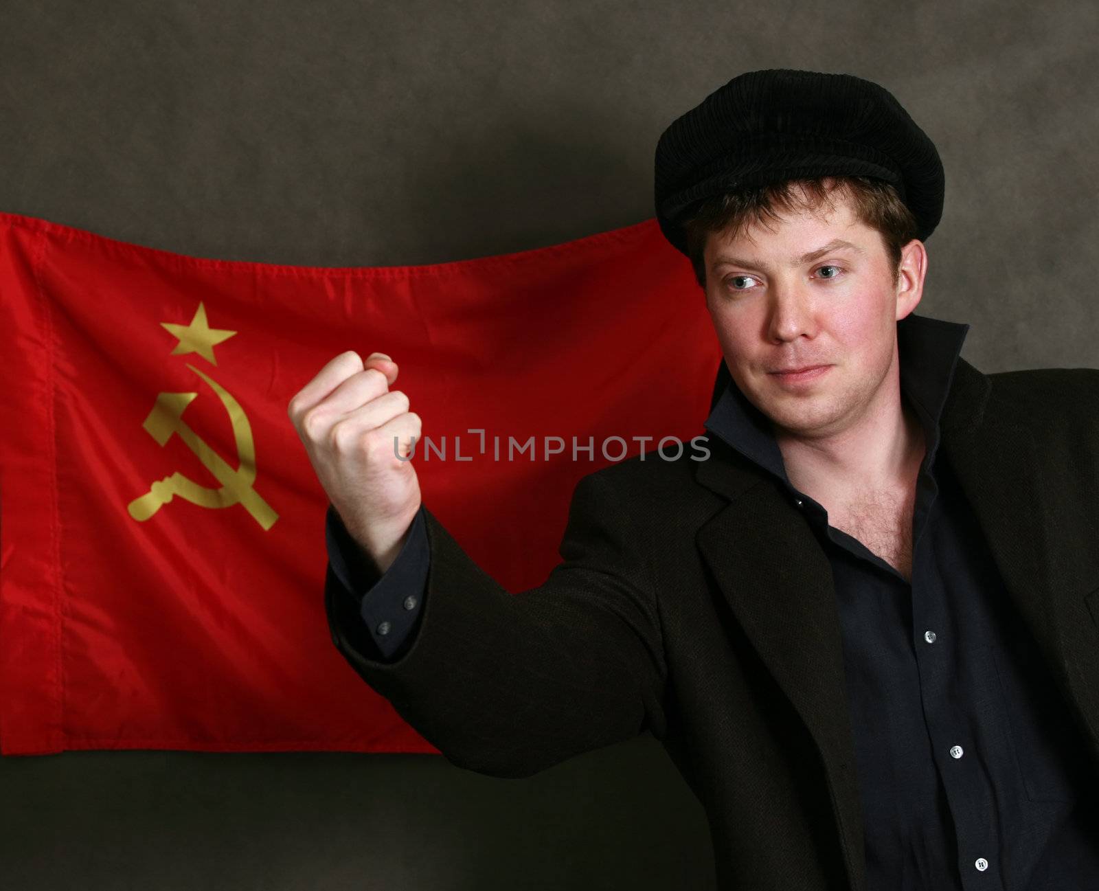 Portrait of the man in a cap on a background of a red flag