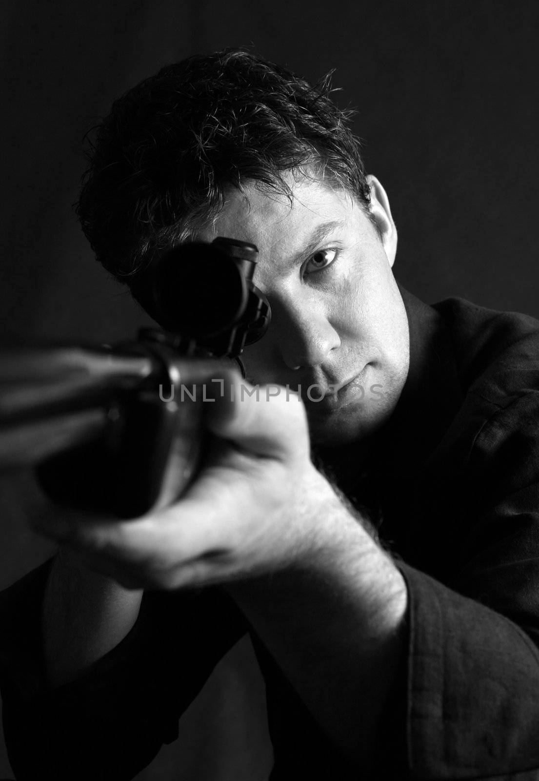 The man with the weapon in studio on a black background